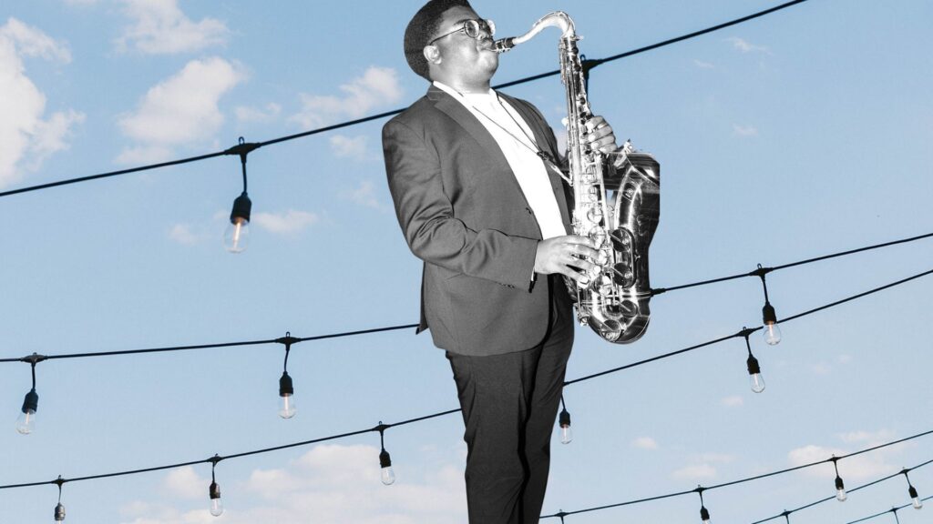 Saxophone player performs on the rooftop beneath string lights during cocktail hour at Solar Arts Building in Minneapolis