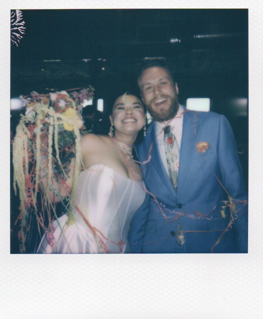 Polaroid of the bride and groom smiling together during their colorful wedding reception at the Solar Arts Building in Minneapolis, Minnesota.