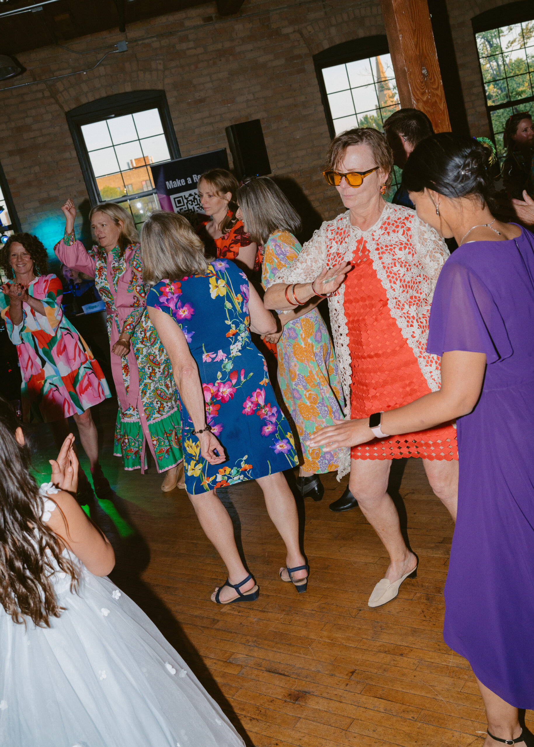 Wedding guests dance together during the colorful reception celebration at Solar Arts Building in Minneapolis.