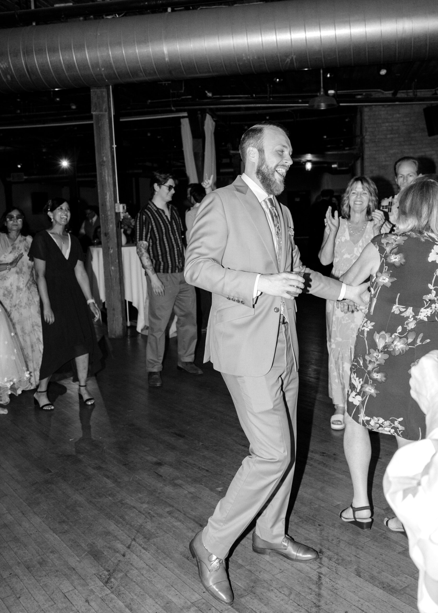 Black-and-white photo of the groom dancing during the wedding reception at Solar Arts Building.