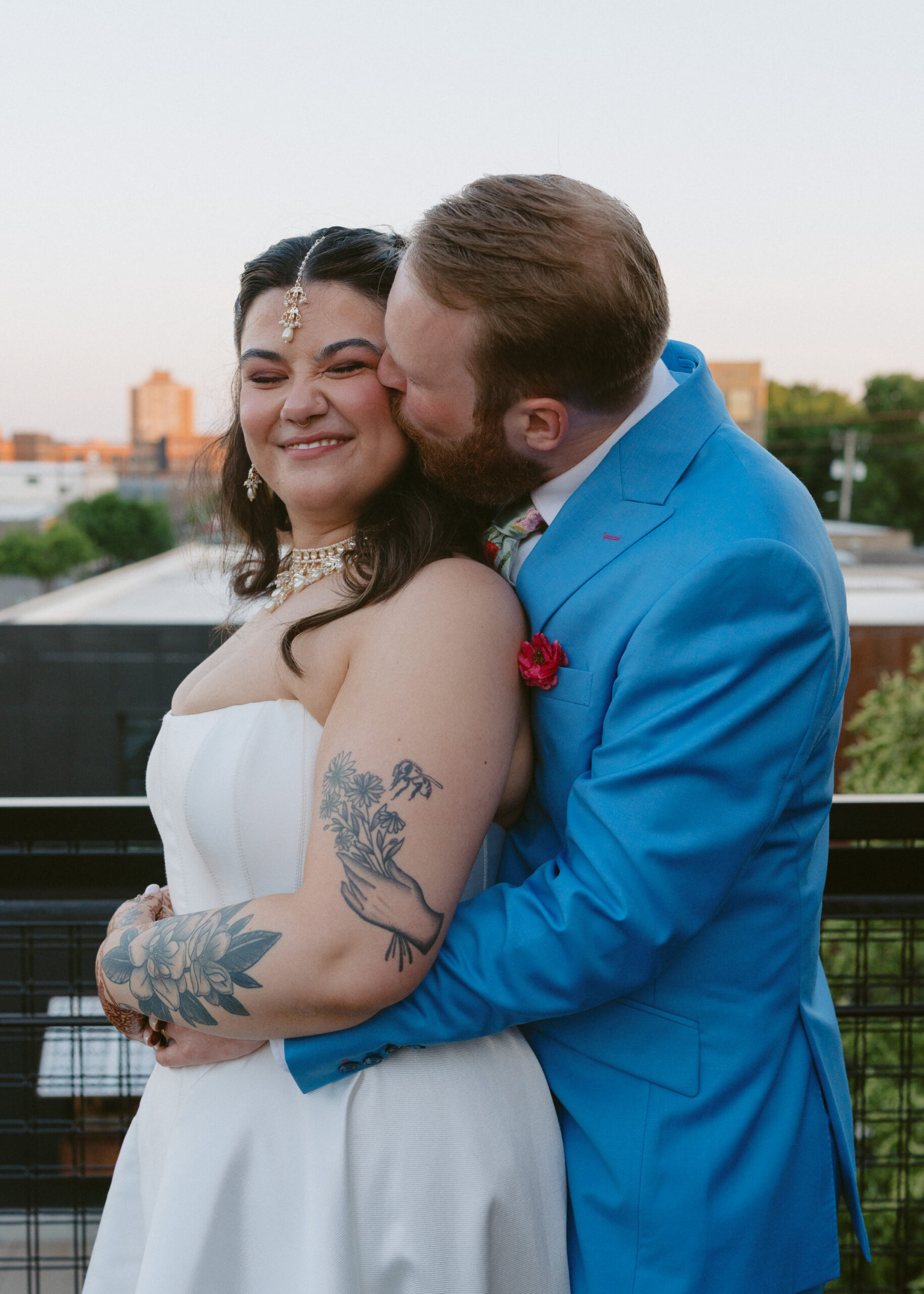 Bride and groom embrace during golden hour portraits on the rooftop of Solar Arts Building in Minneapolis.