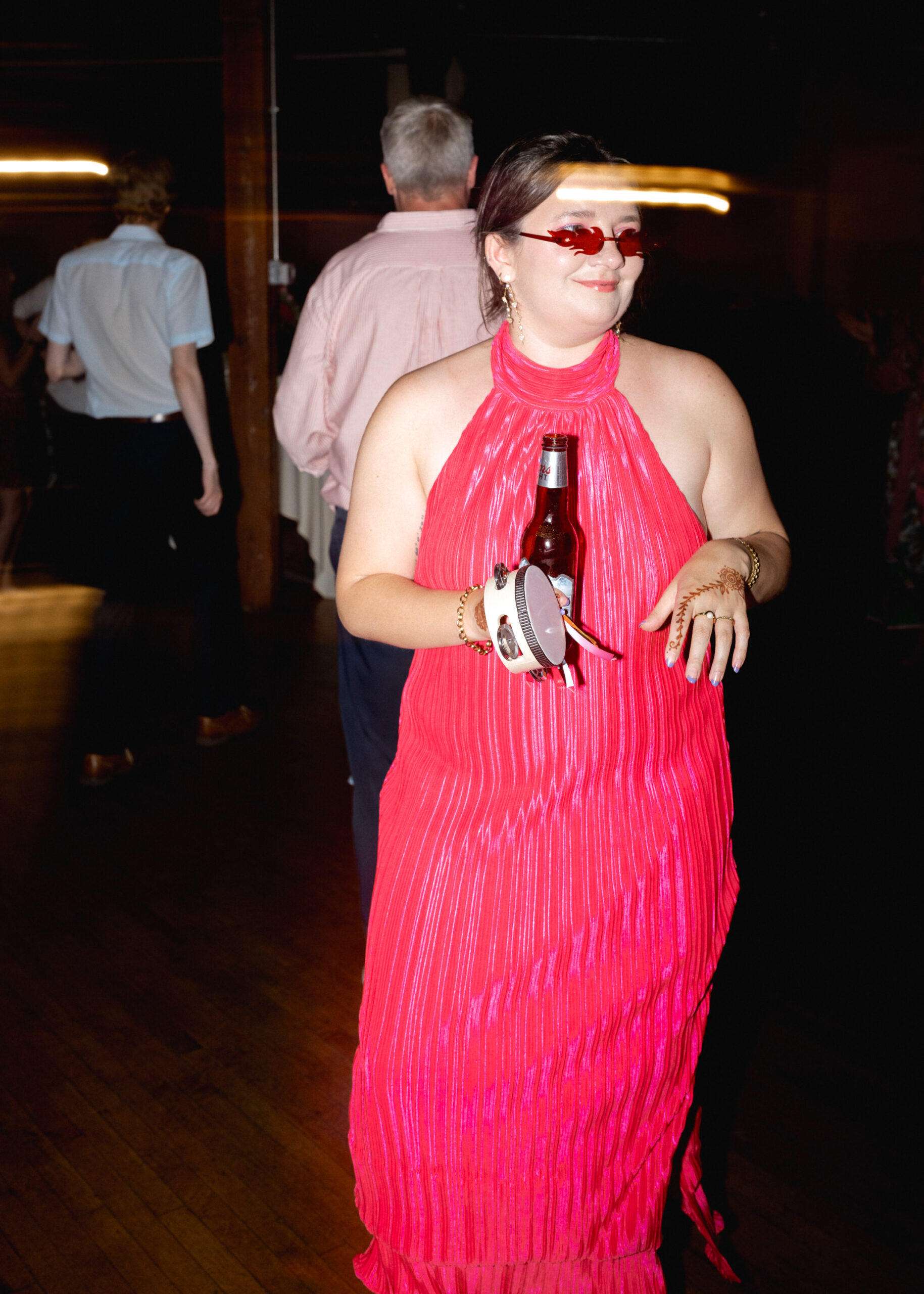 Wedding guest dances in a bright red fringe dress during the lively reception at Solar Arts Building in Minneapolis.