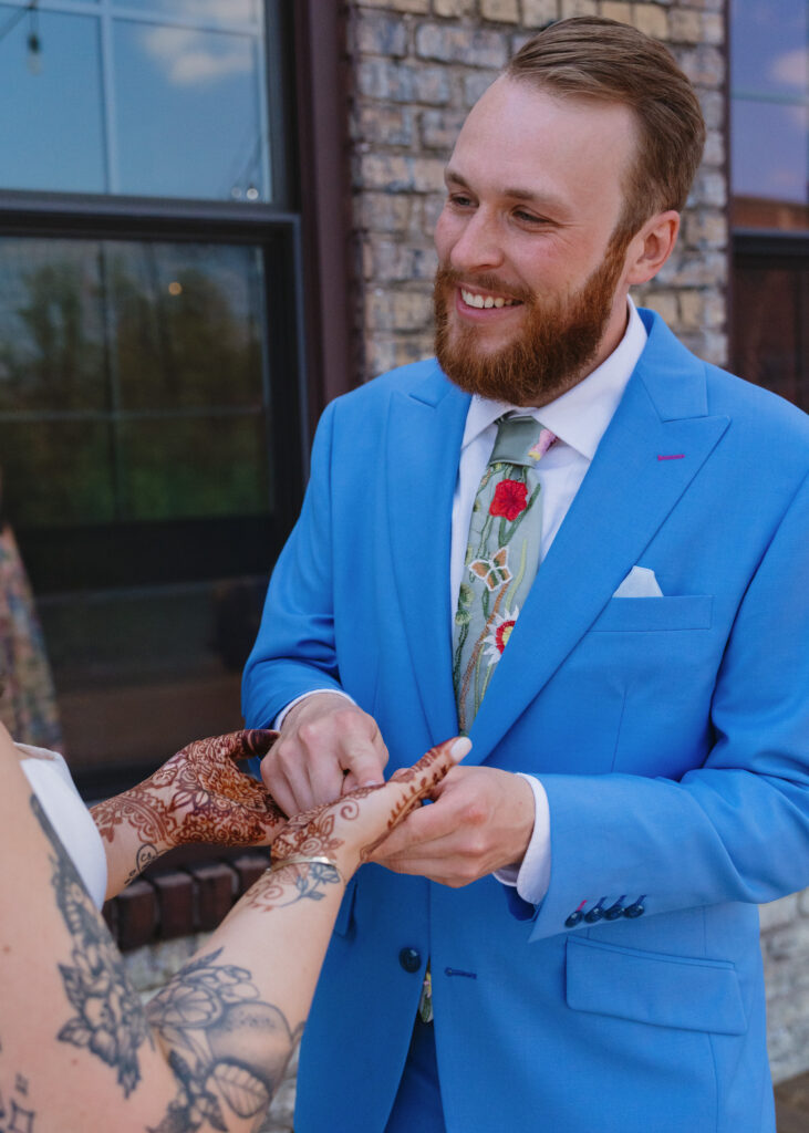Close-up of the bride’s intricate henna as the groom searches for his hidden initials during their wedding day.