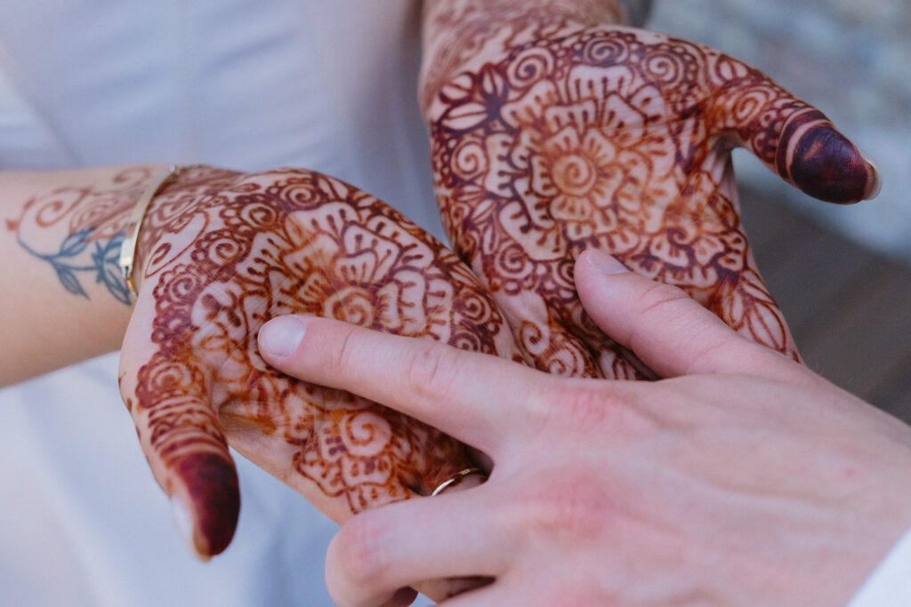 Groom searches for his hidden initials woven into the bride’s intricate henna during their first look.