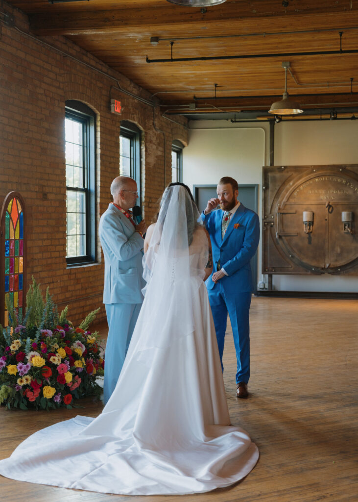 Bride and groom exchange their wedding vows during the ceremony as the officiant looks on.