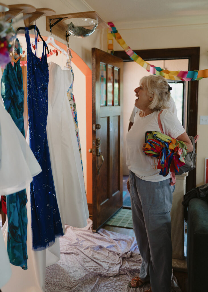 Groom’s mother admires the wedding gown and colorful dresses while getting ready for the wedding day.