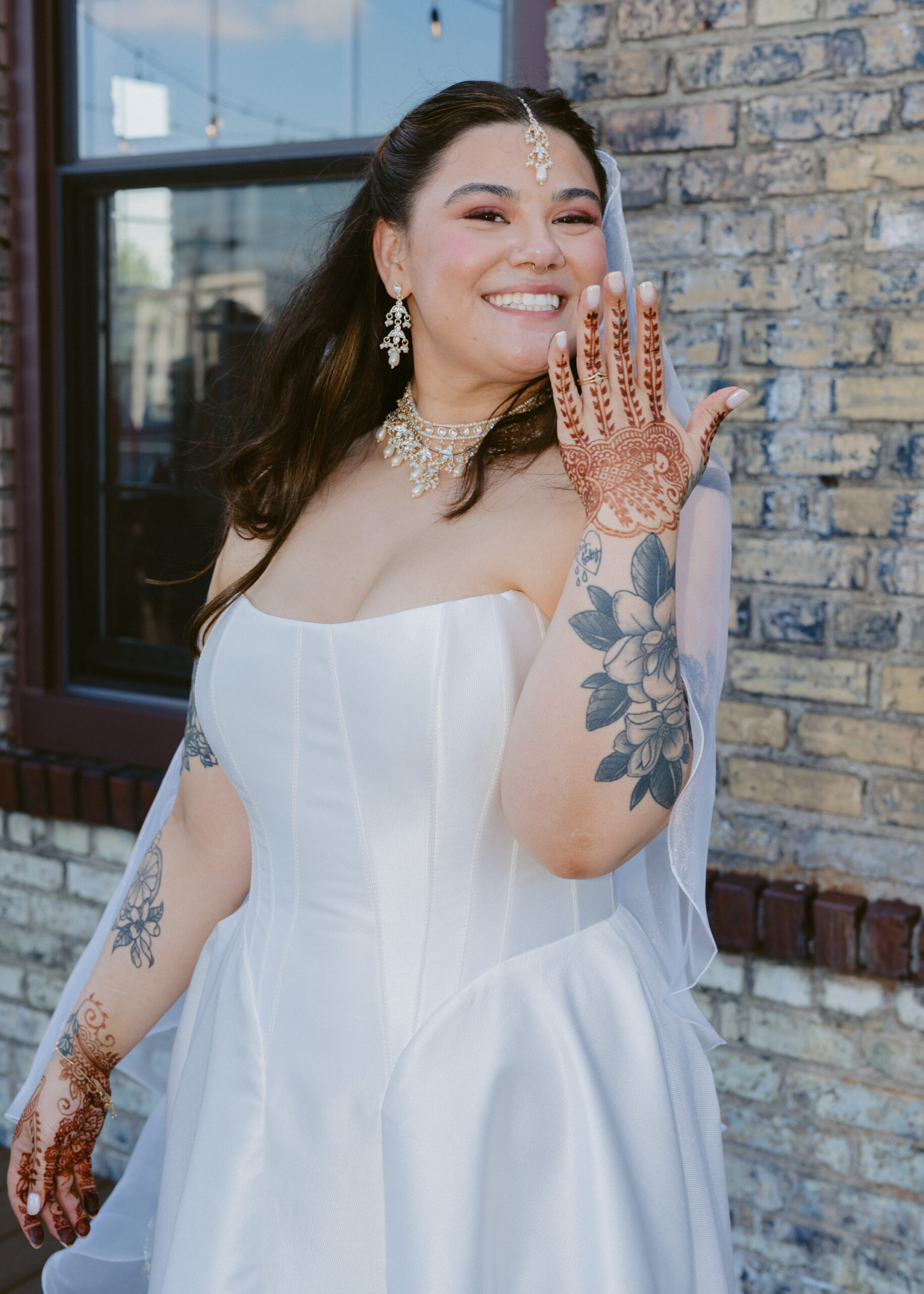 Bride Rishika smiles while showing off her intricate henna during her rooftop wedding reception at Solar Arts Building in Minneapolis.