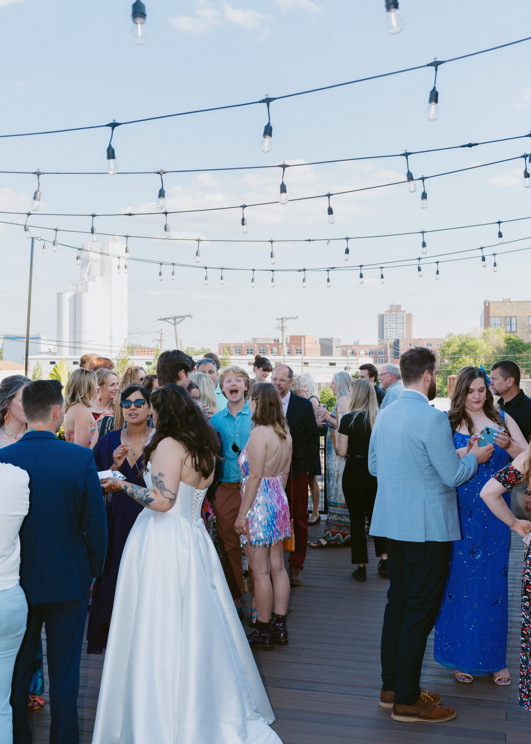 Guests mingle during cocktail hour on the rooftop patio at Solar Arts Building during Rishika and Jethro’s Minneapolis wedding.