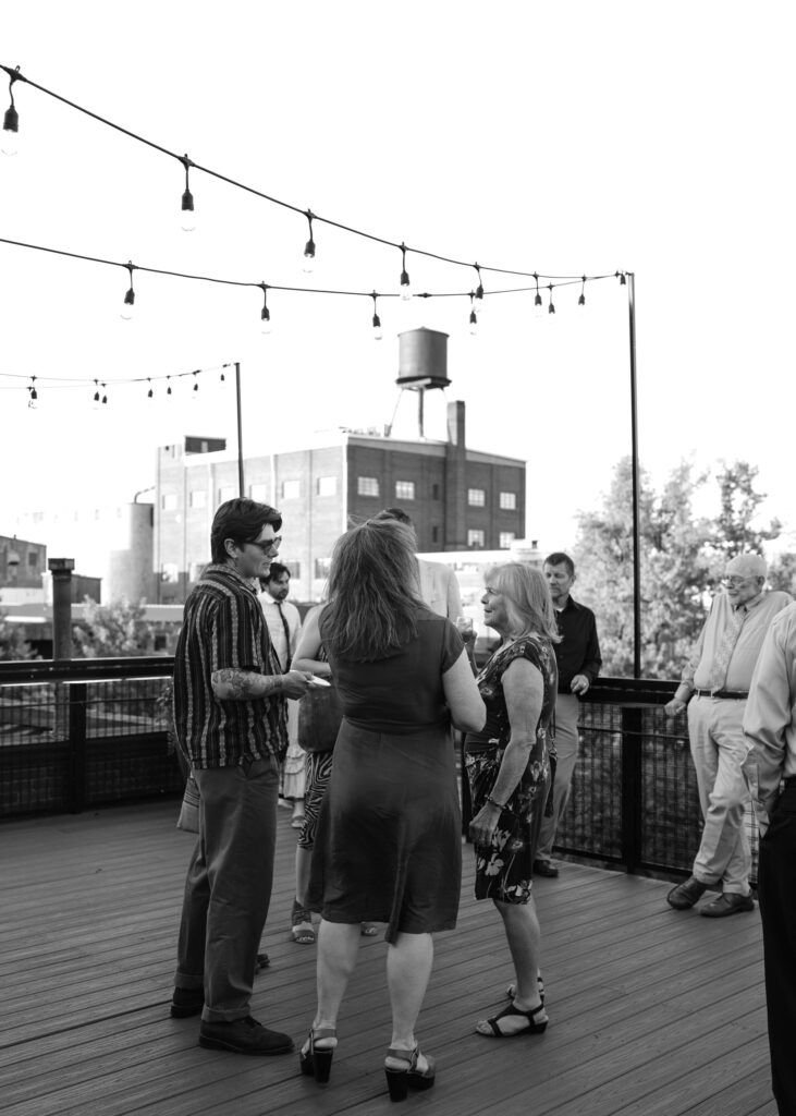 Wedding guests chat on the rooftop patio during cocktail hour at Solar Arts Building in Minneapolis.
